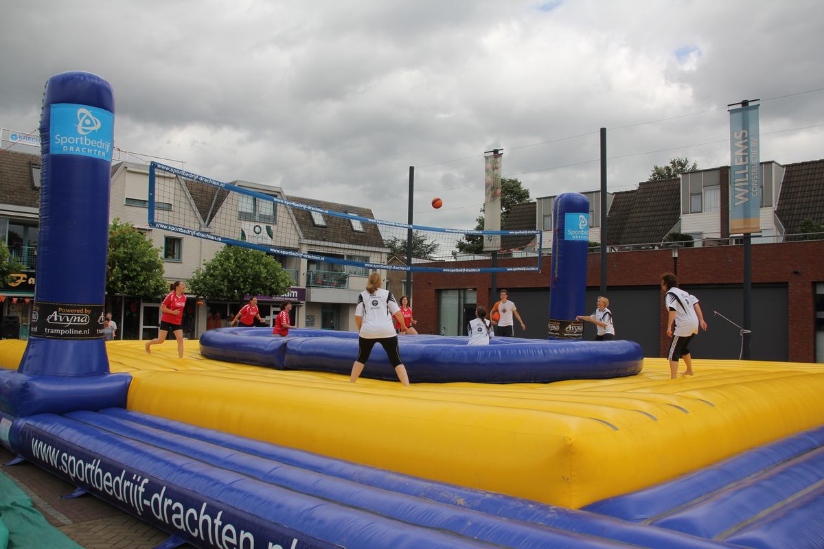 Match de bossaball, joueurs sautant sur des trampolines autour d'un filet